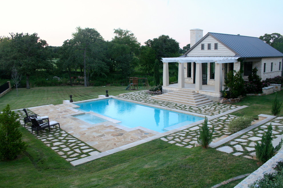 Esempio di un'ampia piscina chic personalizzata dietro casa con pavimentazioni in pietra naturale