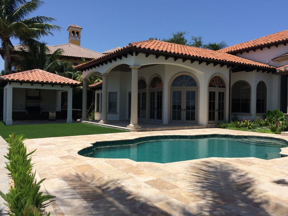 Design ideas for a large mediterranean back custom shaped swimming pool in Miami with tiled flooring.