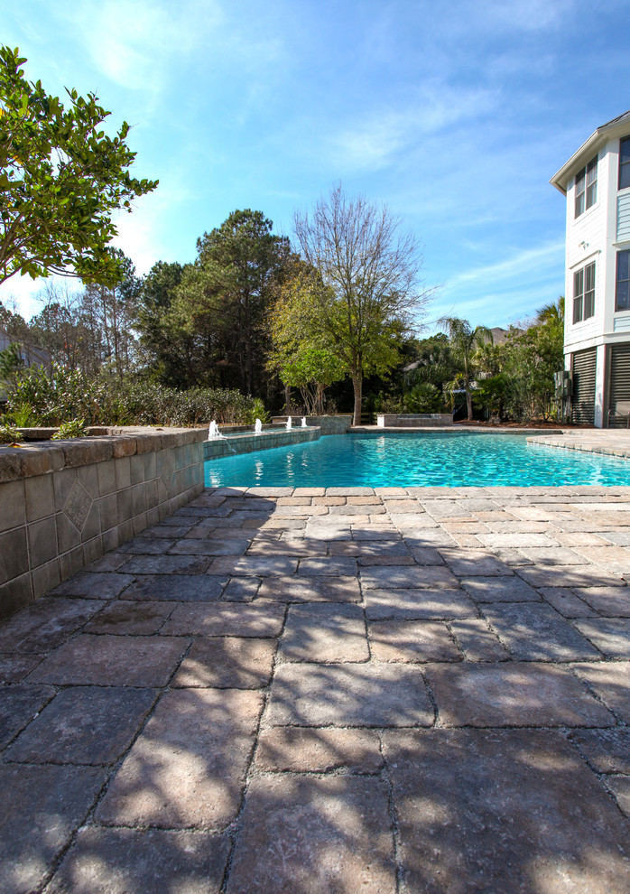 Imagen de piscinas y jacuzzis alargados tropicales grandes a medida en patio trasero con adoquines de hormigón