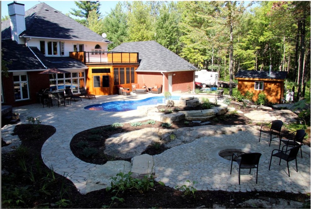 Immagine di una grande piscina monocorsia stile rurale personalizzata dietro casa con fontane e pavimentazioni in pietra naturale