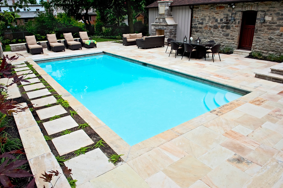 Diseño de piscina con fuente tradicional renovada grande rectangular en patio trasero con adoquines de piedra natural