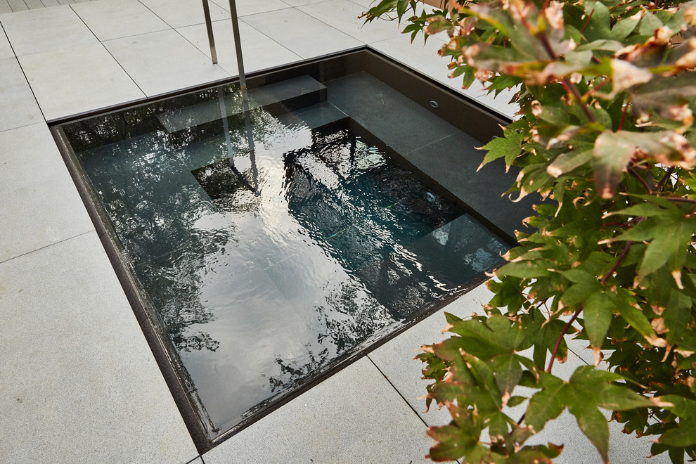 Photo of a contemporary rectangular hot tub in Dallas with natural stone paving.