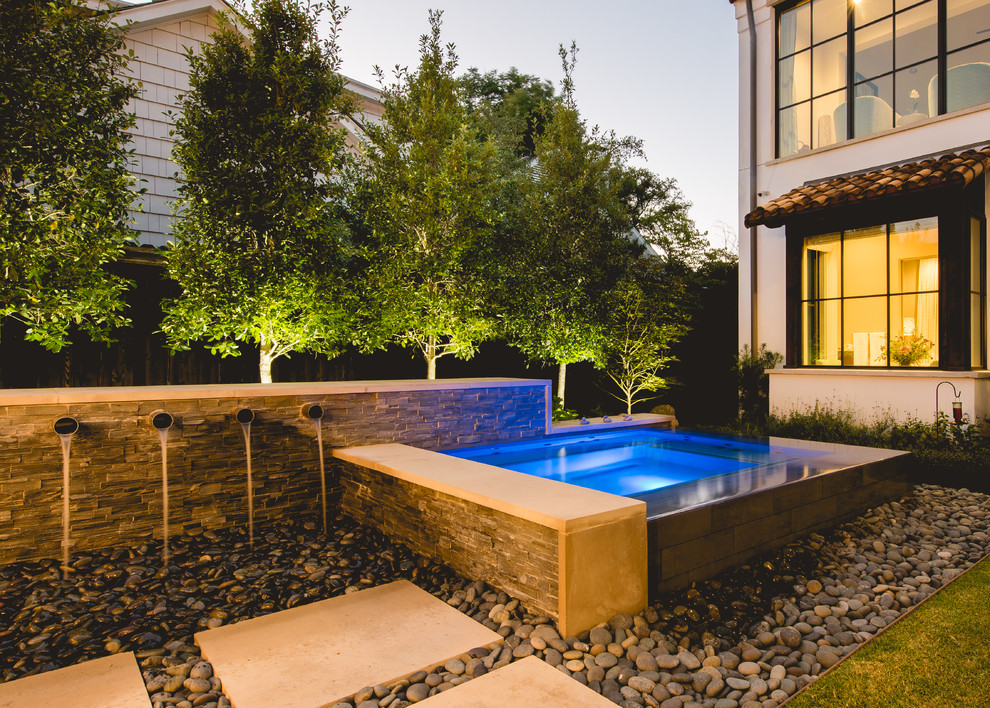 Example of a small trendy backyard rectangular infinity hot tub design in Dallas