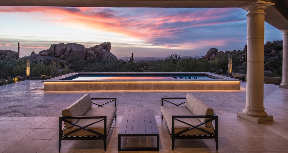 Foto de piscina alargada tradicional renovada de tamaño medio rectangular en patio trasero con adoquines de piedra natural