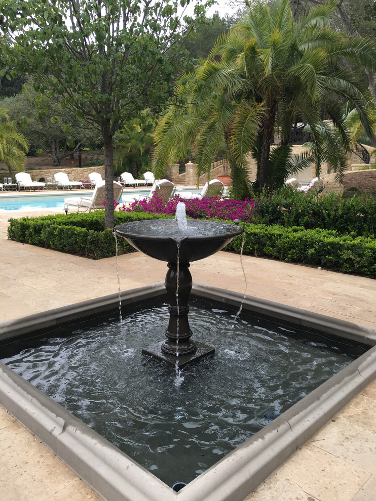 Modelo de piscina con fuente alargada tradicional extra grande rectangular en patio con adoquines de piedra natural