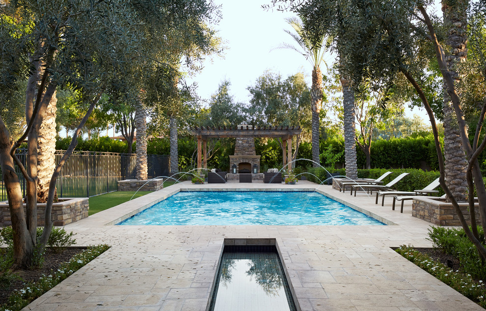 Imagen de piscina con fuente mediterránea rectangular en patio trasero