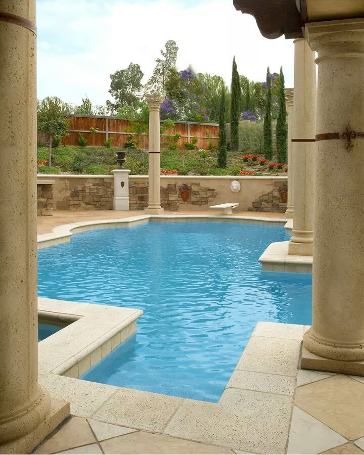 Foto de piscina con fuente natural retro grande a medida en patio trasero con adoquines de piedra natural