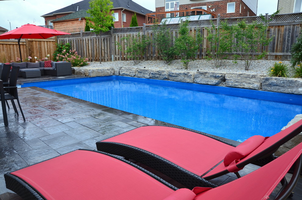 Esempio di una piscina design rettangolare con pavimentazioni in cemento
