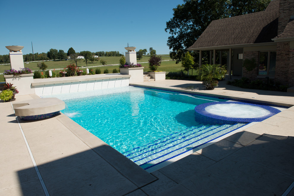 Ejemplo de piscinas y jacuzzis actuales grandes rectangulares en patio con suelo de hormigón estampado