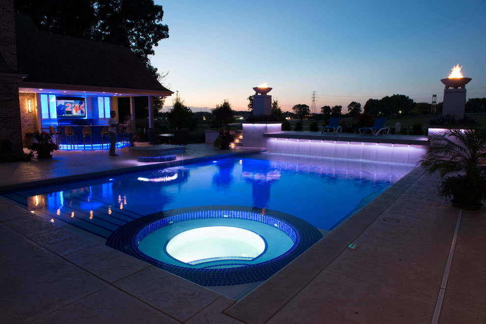 Foto di una grande piscina contemporanea rettangolare in cortile con una vasca idromassaggio e cemento stampato