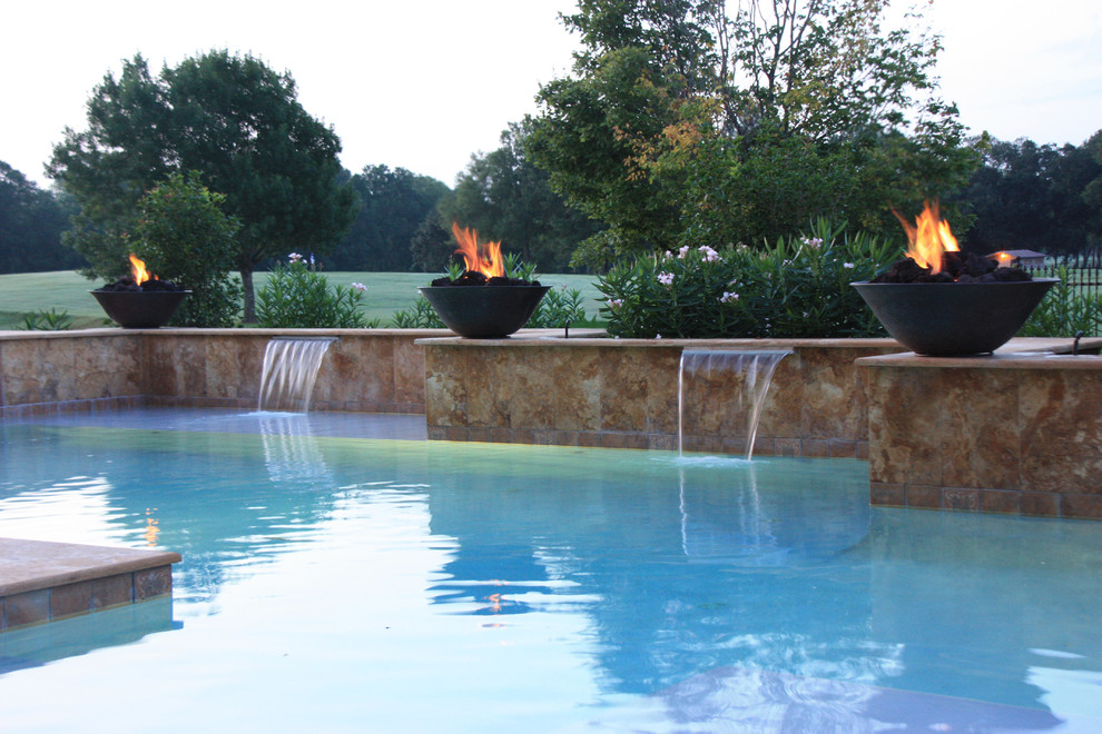 Design ideas for a medium sized contemporary back custom shaped swimming pool in New Orleans with a water feature and natural stone paving.
