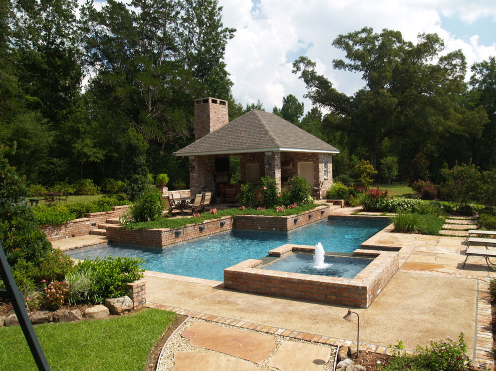 Example of a mid-sized classic backyard stone and custom-shaped hot tub design in New Orleans