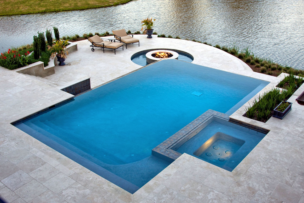 Example of a mid-sized trendy backyard concrete paver and rectangular infinity pool fountain design in New Orleans