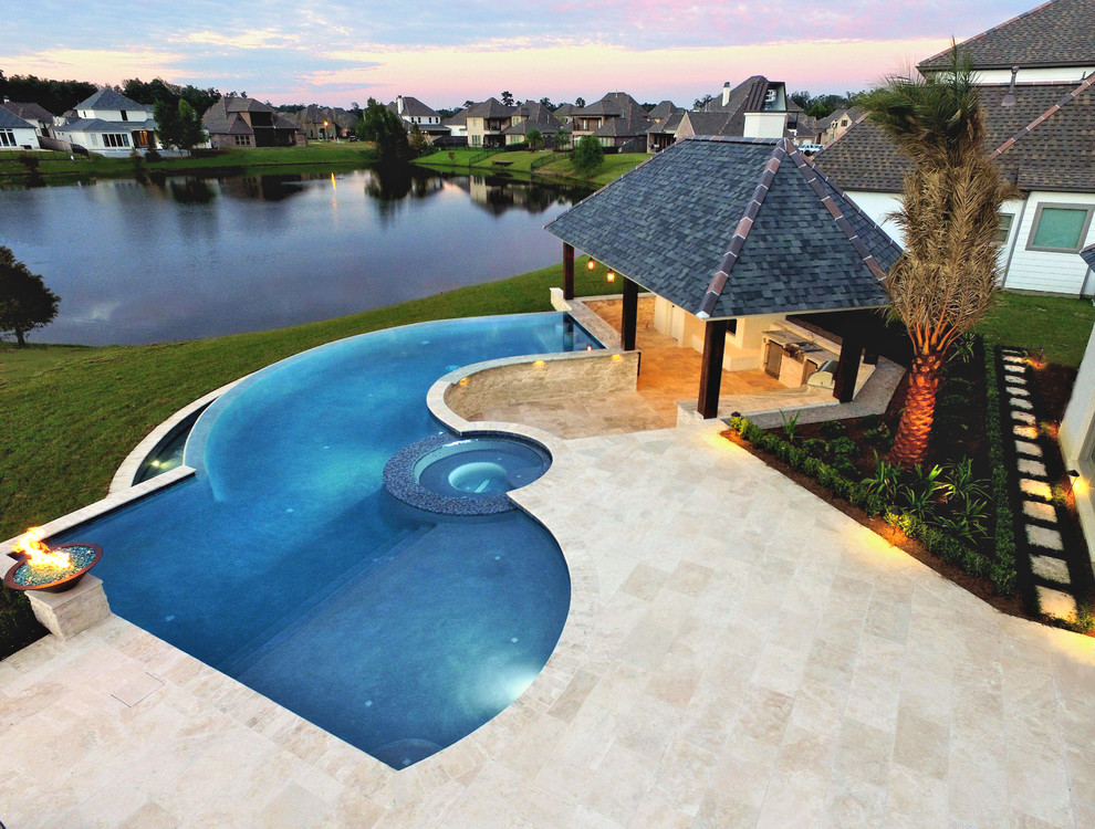Diseño de casa de la piscina y piscina infinita actual grande a medida en patio trasero con entablado