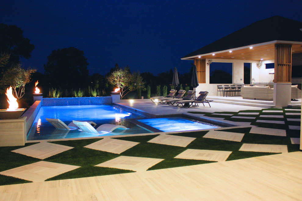 Imagen de casa de la piscina y piscina alargada actual de tamaño medio rectangular en patio trasero con adoquines de hormigón