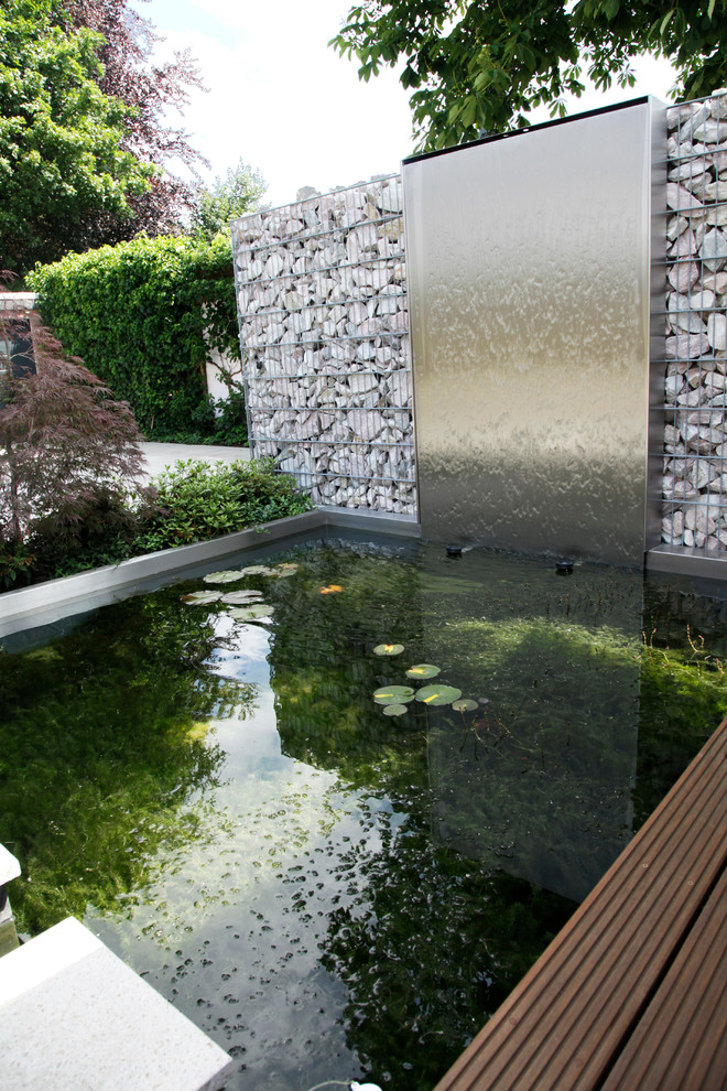 Идея дизайна: естественный, прямоугольный бассейн среднего размера в современном стиле с фонтаном и настилом
