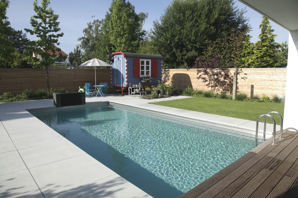 Ispirazione per una piscina monocorsia design rettangolare di medie dimensioni e dietro casa con una dépendance a bordo piscina e piastrelle