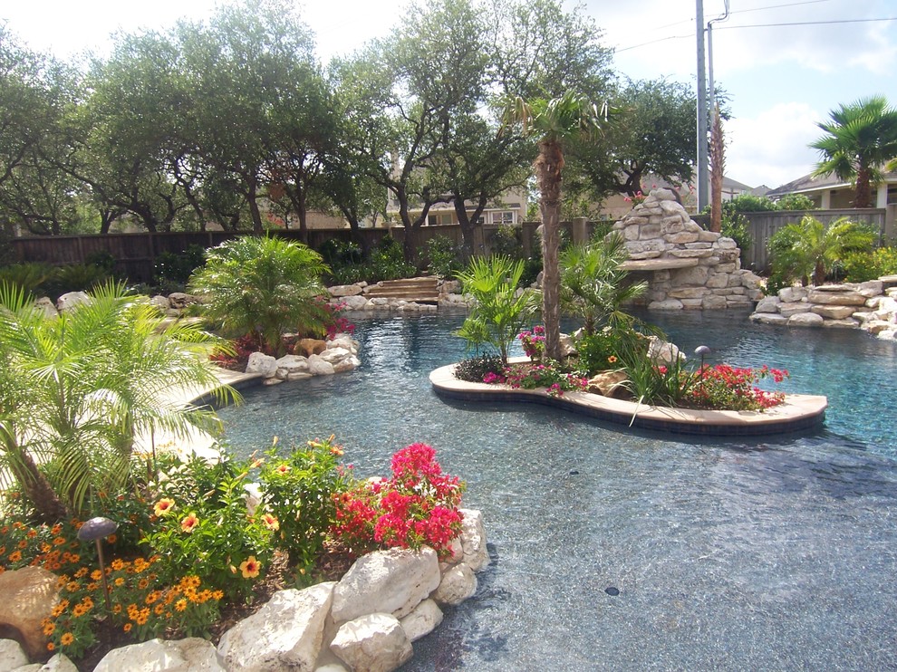 Стильный дизайн: огромный естественный бассейн произвольной формы на заднем дворе в средиземноморском стиле с домиком у бассейна и покрытием из каменной брусчатки - последний тренд