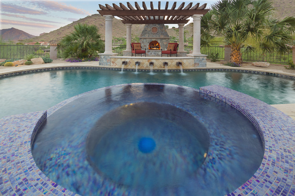 Immagine di una grande piscina naturale mediterranea personalizzata dietro casa con una vasca idromassaggio e pavimentazioni in cemento
