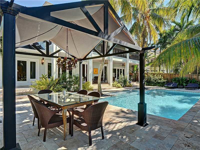 Foto de piscina natural tropical grande rectangular en patio trasero con adoquines de piedra natural