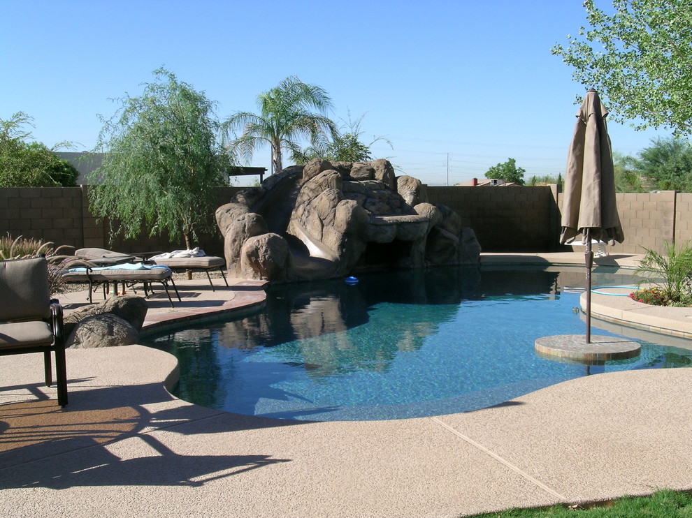 Foto de piscina con fuente natural tradicional de tamaño medio tipo riñón en patio trasero con entablado