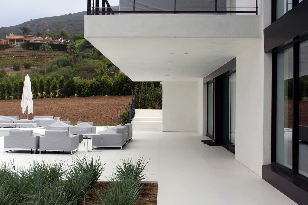 Exemple d'une grande terrasse arrière moderne avec une dalle de béton.