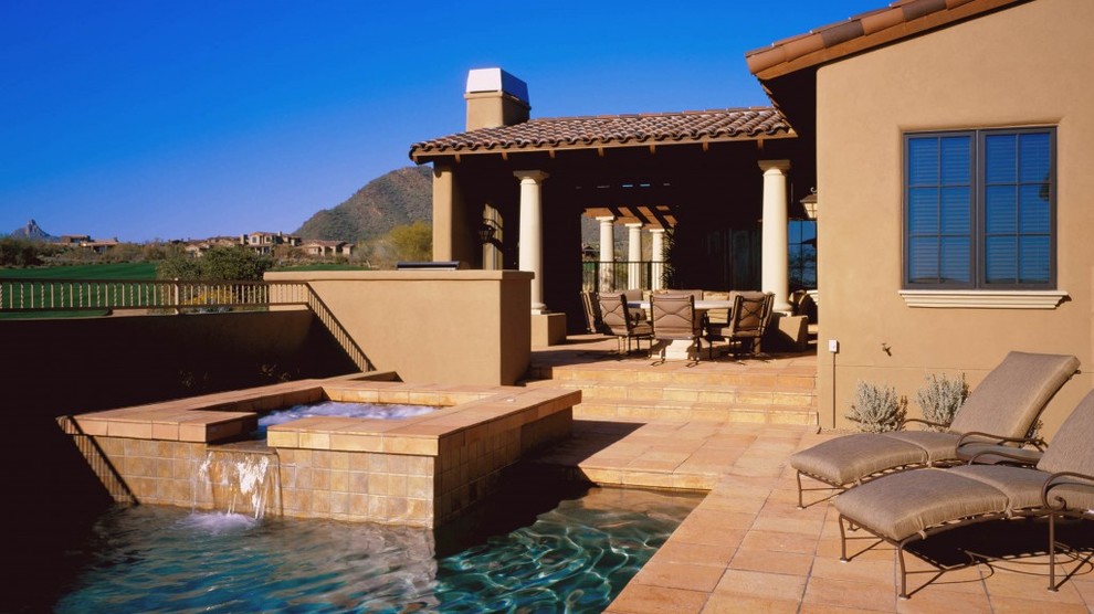 Esempio di una piscina american style rettangolare dietro casa con fontane e piastrelle
