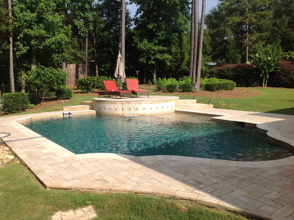 Пример оригинального дизайна: бассейн среднего размера, произвольной формы на заднем дворе в классическом стиле с фонтаном и мощением тротуарной плиткой