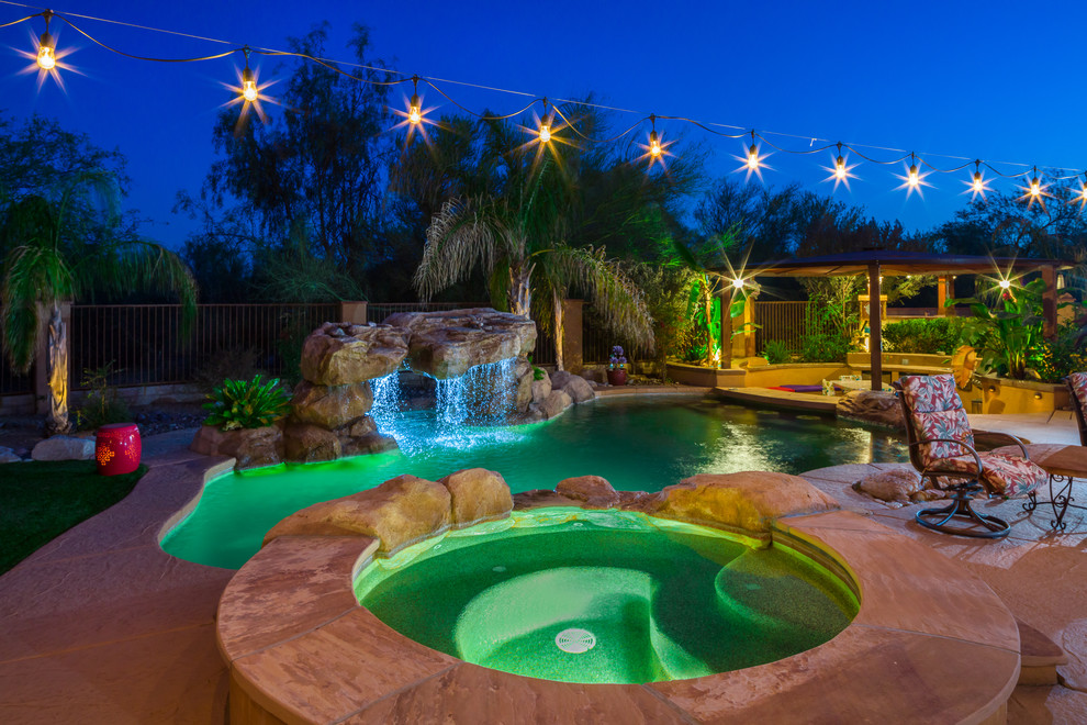 Ejemplo de piscinas y jacuzzis alargados de estilo americano a medida en patio trasero con suelo de baldosas