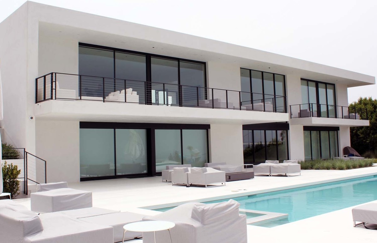 Immagine di una grande piscina monocorsia moderna rettangolare dietro casa con lastre di cemento