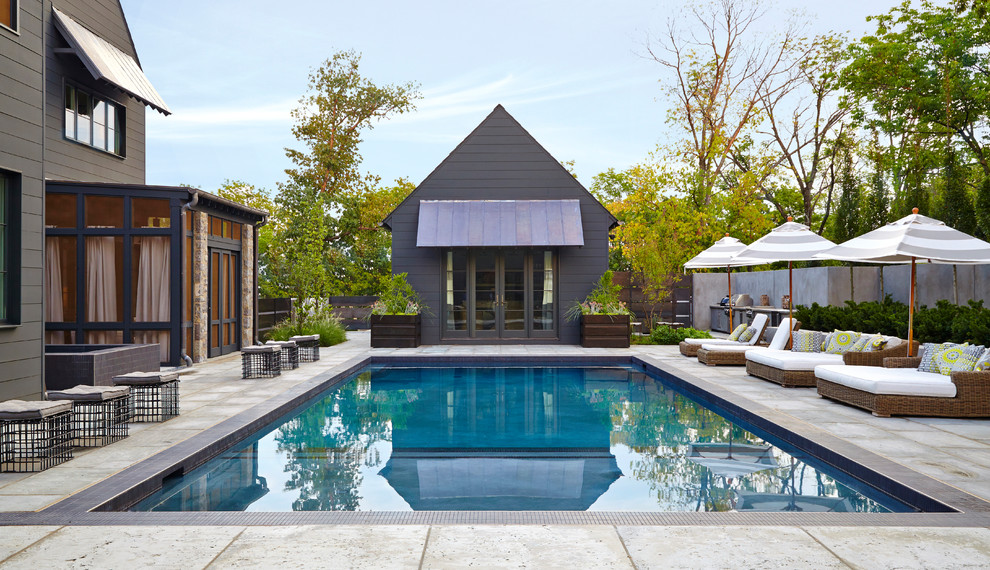 Стильный дизайн: прямоугольный бассейн на заднем дворе в стиле неоклассика (современная классика) с домиком у бассейна и покрытием из бетонных плит - последний тренд