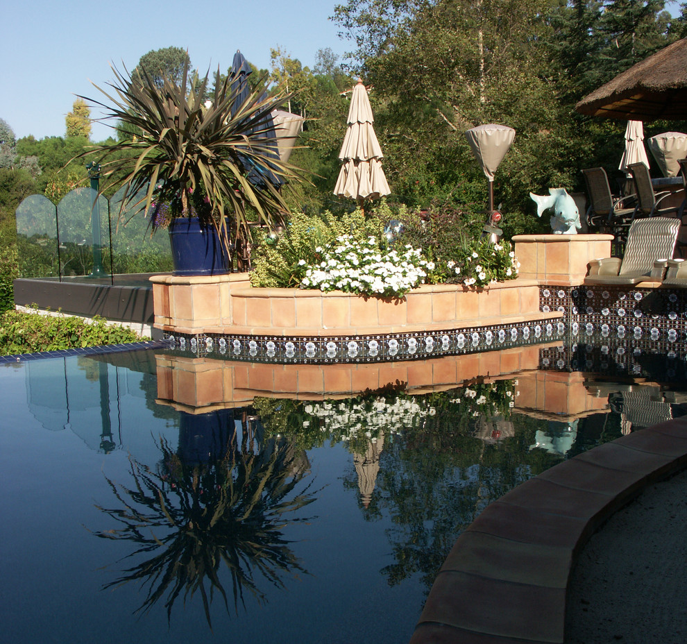 Idéer för att renovera en stor medelhavsstil anpassad pool på baksidan av huset, med en fontän och kakelplattor