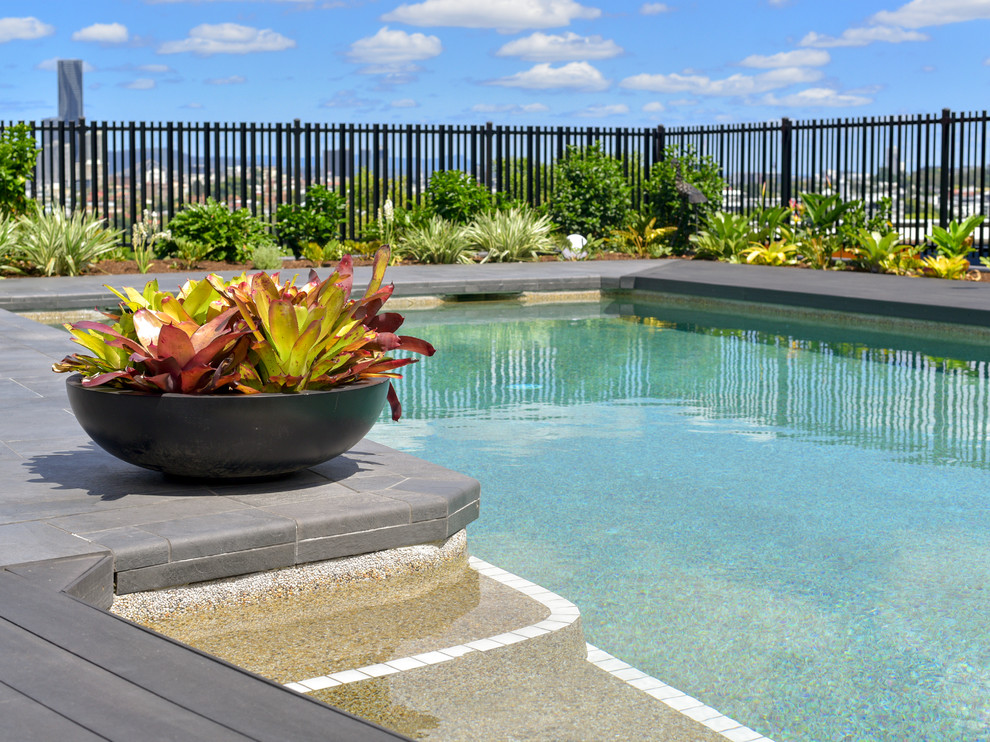 Ispirazione per una piscina tropicale rettangolare dietro casa con pedane