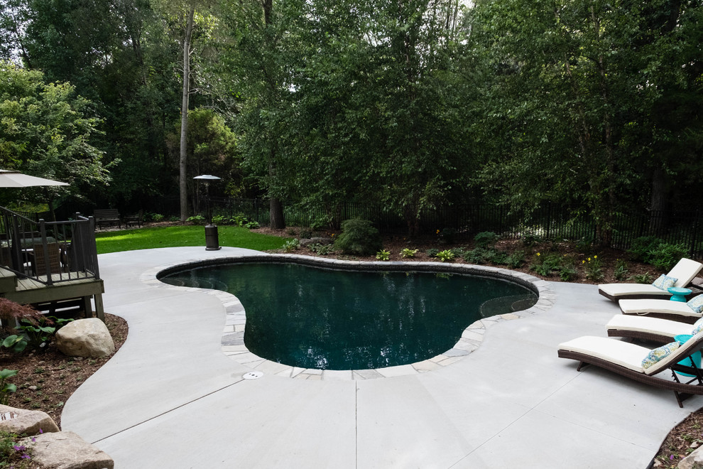Modelo de piscina con fuente natural clásica de tamaño medio a medida en patio trasero con adoquines de piedra natural