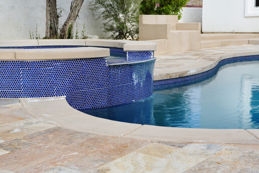 Идея дизайна: большой естественный бассейн произвольной формы на заднем дворе в средиземноморском стиле с джакузи и покрытием из бетонных плит