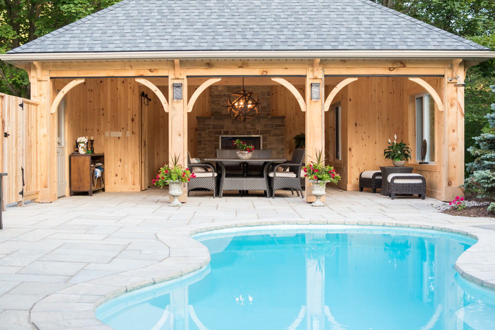 Imagen de casa de la piscina y piscina rural de tamaño medio en patio trasero con adoquines de hormigón