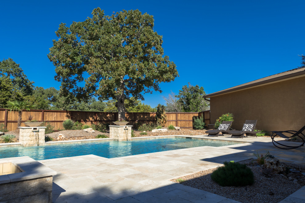 Exemple d'une grande piscine arrière tendance rectangle avec un point d'eau et une terrasse en bois.