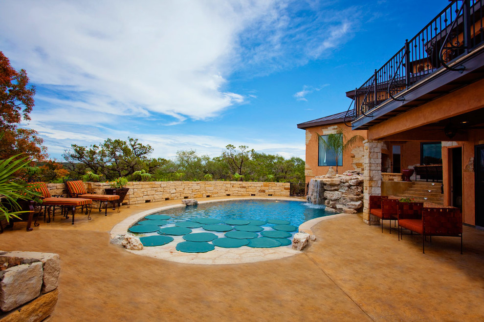 Пример оригинального дизайна: естественный бассейн на заднем дворе в средиземноморском стиле с джакузи и покрытием из каменной брусчатки
