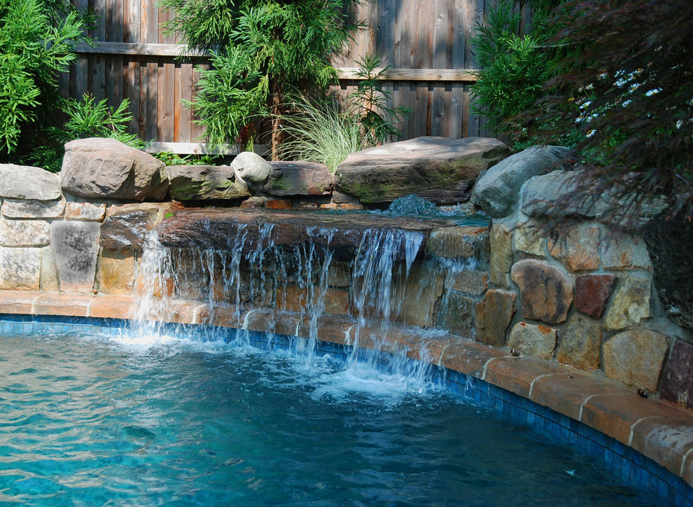 Ejemplo de piscina con fuente natural ecléctica de tamaño medio a medida en patio trasero con adoquines de hormigón