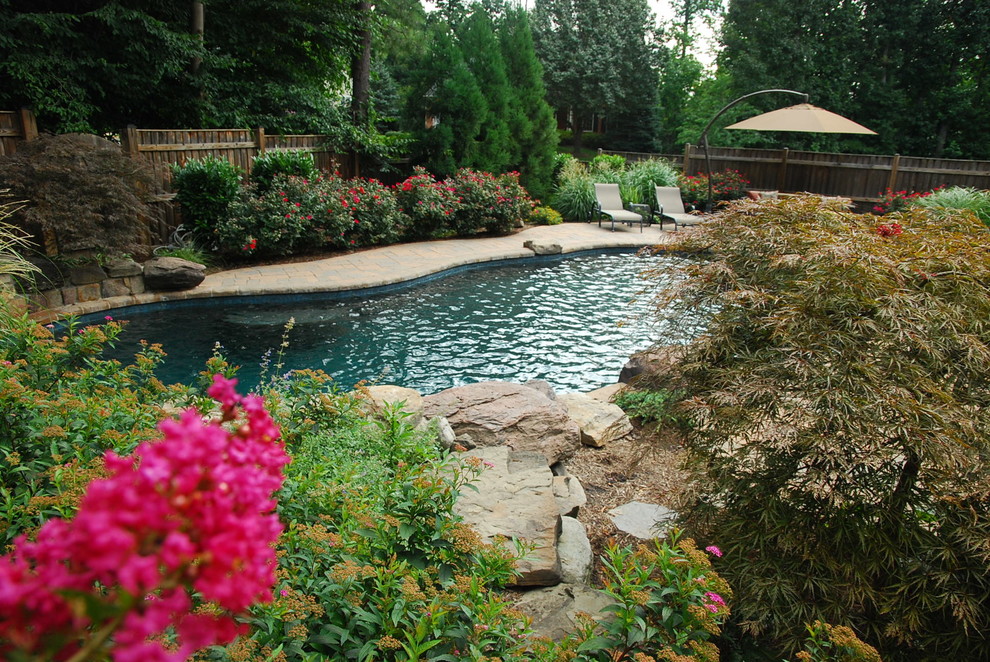 Ejemplo de piscina natural bohemia de tamaño medio a medida con adoquines de hormigón