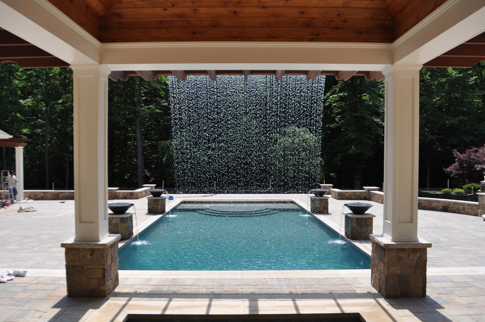 На фото: огромный спортивный, прямоугольный бассейн на заднем дворе в классическом стиле с фонтаном и мощением тротуарной плиткой с
