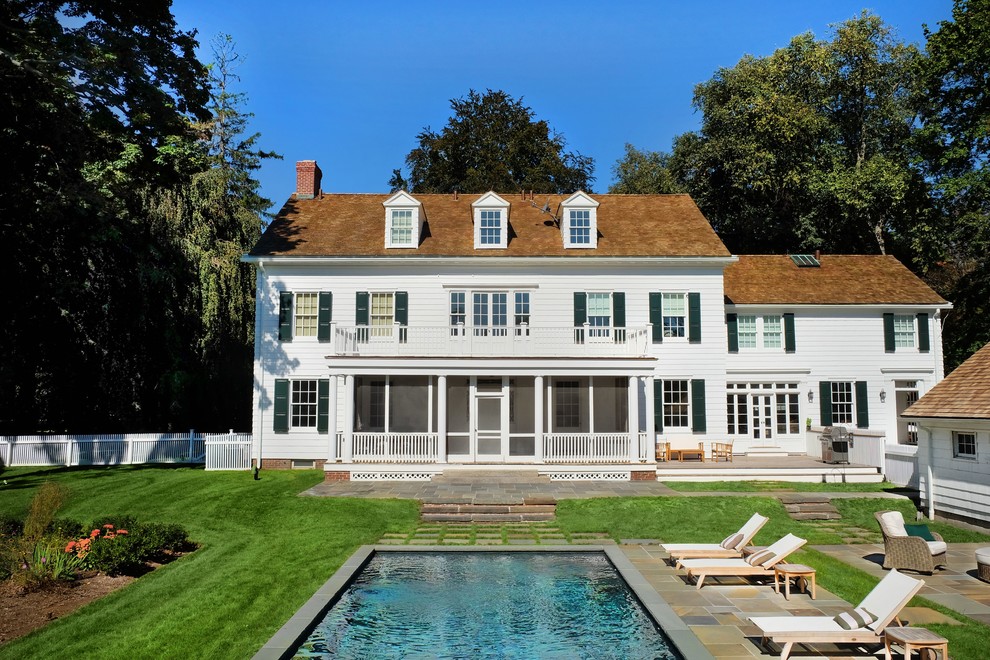 Imagen de piscina alargada de estilo de casa de campo de tamaño medio rectangular en patio trasero con suelo de baldosas