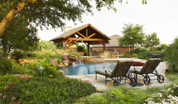 Immagine di una piscina chic personalizzata dietro casa con pavimentazioni in pietra naturale