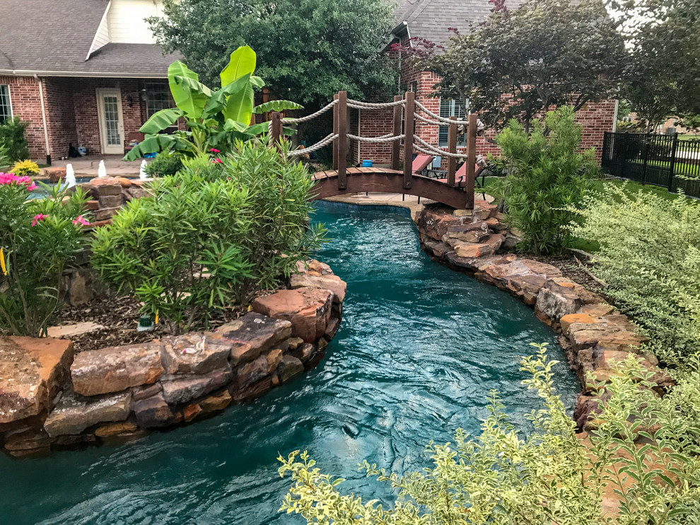 Geräumiger Uriger Pool hinter dem Haus in individueller Form mit Wasserrutsche und Natursteinplatten in Dallas
