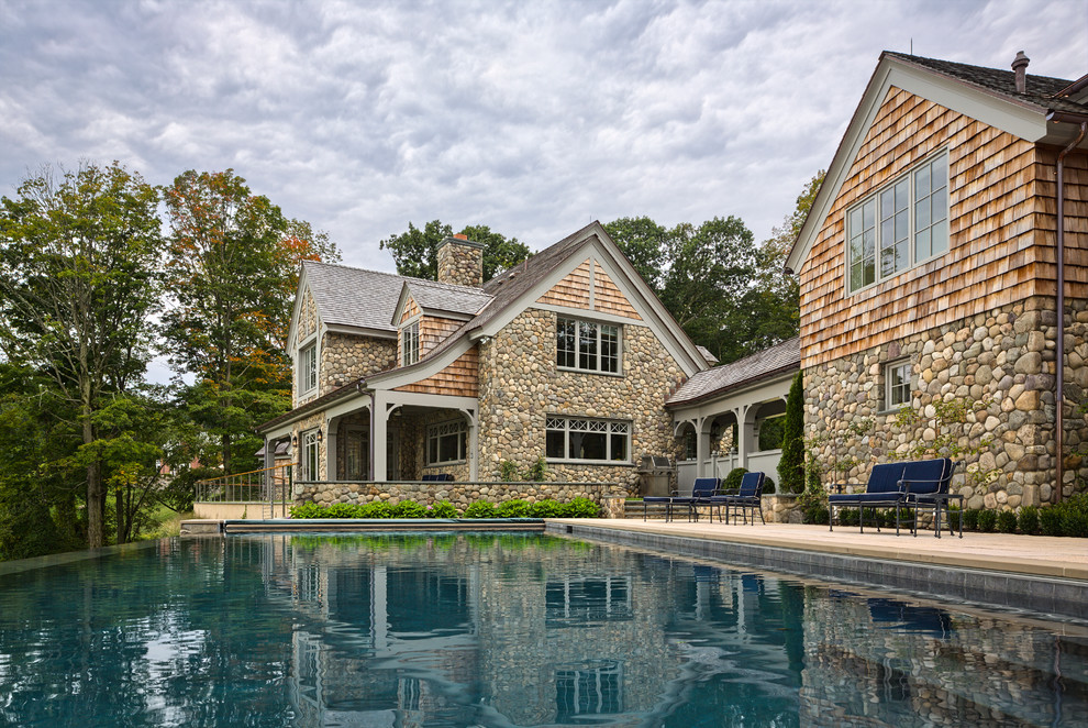 Diseño de casa de la piscina y piscina infinita tradicional renovada extra grande rectangular en patio trasero con adoquines de hormigón