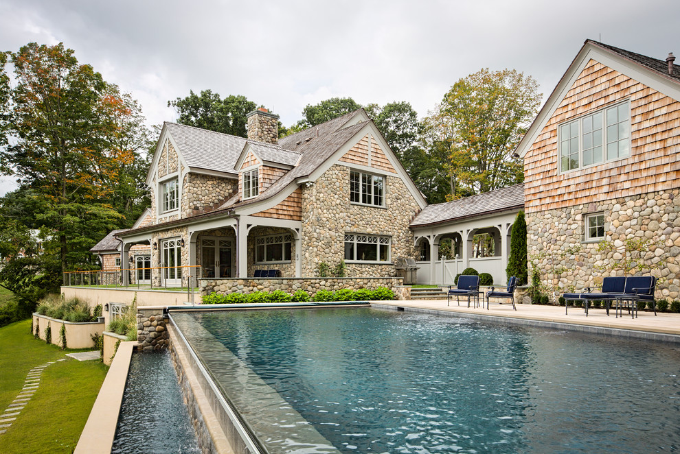 Cette photo montre un très grand Abris de piscine et pool houses arrière chic rectangle avec des pavés en béton.