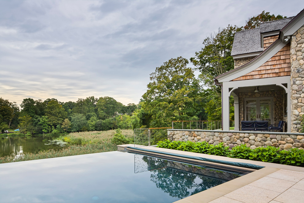 Foto de casa de la piscina y piscina infinita tradicional renovada extra grande rectangular en patio trasero con adoquines de hormigón