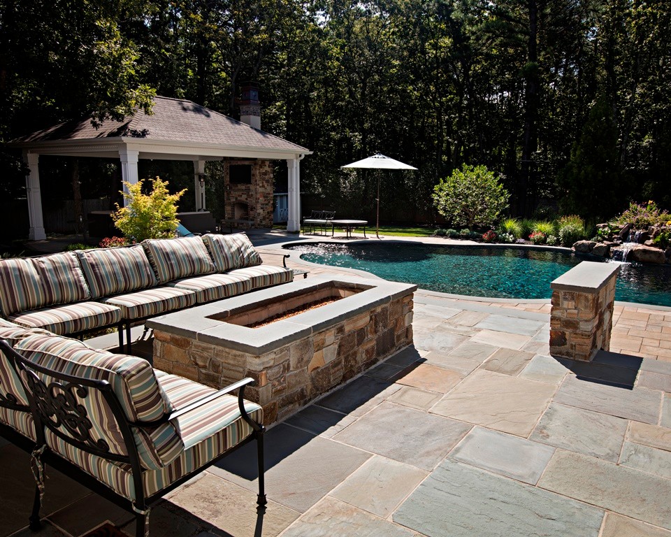 Pool house - large traditional backyard stone and custom-shaped pool house idea in Philadelphia