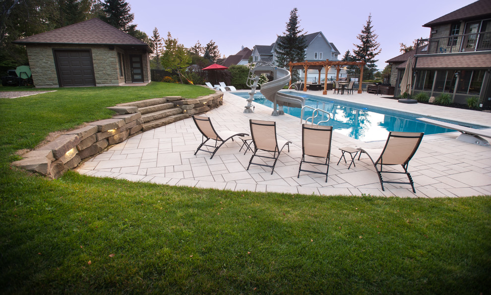 Inspiration pour une très grande piscine arrière traditionnelle rectangle avec des pavés en béton.
