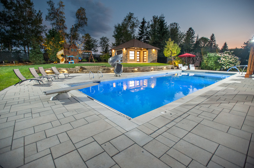Cette image montre une très grande piscine arrière traditionnelle rectangle avec des pavés en béton.